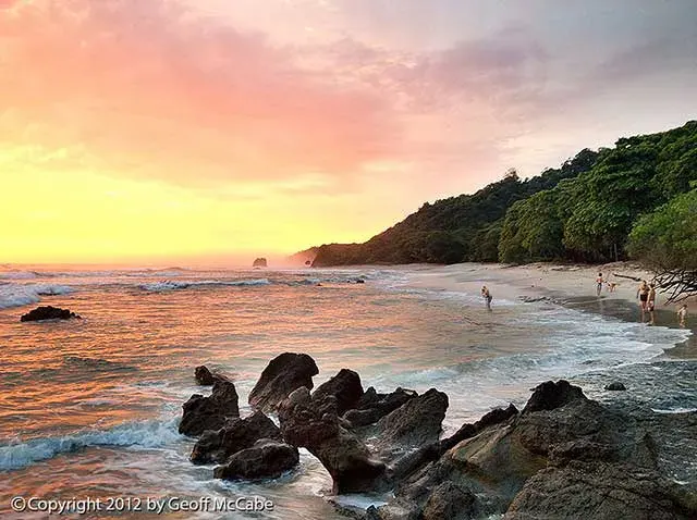 Sunset over the rocks and surf at La Lora beach in Santa Teresa